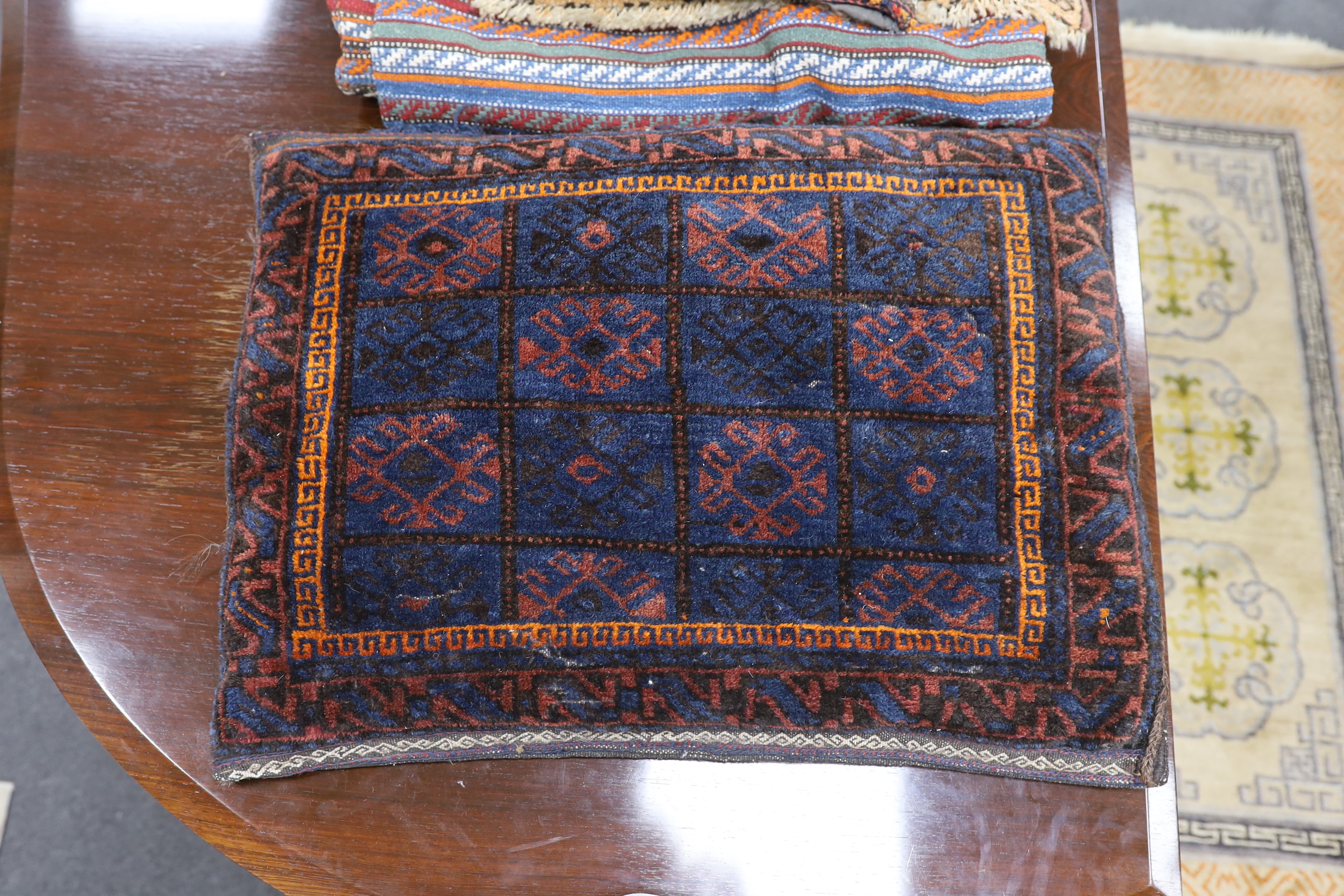 A Belouch cushion, two textile fragments, a Caucasian geometric salt bag, Caucasian mat and a flatweave rug, largest 220 x 205cm
